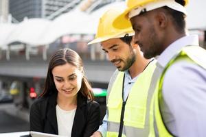 zakenvrouw en werknemer bespreken met ingenieur op bouwplaats. foto