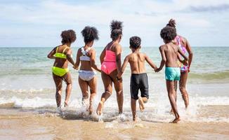 kinderen spelen rennend op zand op het strand foto