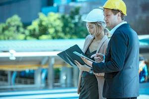 de ingenieur en zakenmensen geven high five tegen bouwen. het concept van engineering, constructie, stadsleven en toekomst. foto