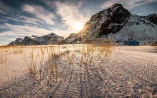 zonsopgang op berg met graspol op besneeuwd foto