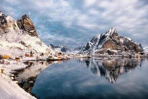 landschap van vissersdorp reine met bergen reflectie op de kustlijn in de winter op de lofoten-eilanden foto