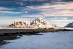 landschap van zonlicht schijnt op besneeuwde bergketen aan de kust foto