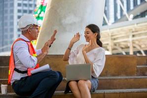 de ingenieur en zakenmensen geven high five tegen bouwen. het concept van engineering, constructie, stadsleven en toekomst. foto