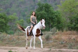 jonge vrouw met haar paard in avondzonsonderganglicht. buitenfotografie met fotomodel meisje. levensstijl stemming foto