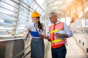 de ingenieur en zakenmensen geven high five tegen bouwen. het concept van engineering, constructie, stadsleven en toekomst. foto