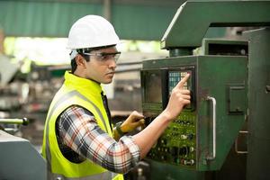 voorman of arbeider werkt op fabriekslocatie controleer machine of producten op locatie. ingenieur of technicus die materiaal of machine op de fabriek controleert. industrieel en fabriek. foto