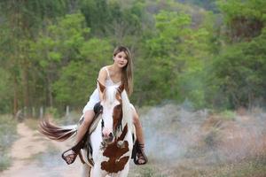 jonge vrouw met haar paard in avondzonsonderganglicht. buitenfotografie met fotomodel meisje. levensstijl stemming foto