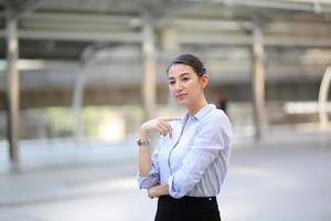 portret van jonge mooie zakenvrouw aan de buitenkant. gekruiste armen foto