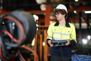 ingenieur controleert het bedieningspaneel en leert nieuwe automaten robotarm en bedieningsmachine in de fabriek. foto