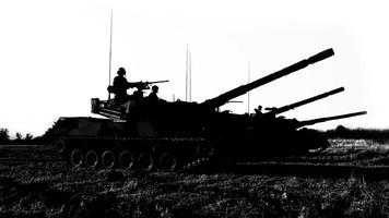 silhouetten van legersoldaten in de mist tegen een zonsondergang, mariniersteam in actie, omringd door vuur en rook, schietend met aanvalsgeweer en machinegeweer, aanvallende vijand foto