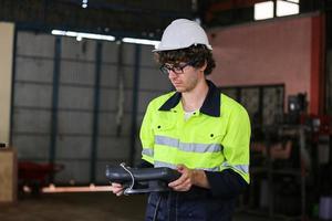 ingenieur controleert het bedieningspaneel en leert nieuwe automaten robotarm en bedieningsmachine in de fabriek. foto