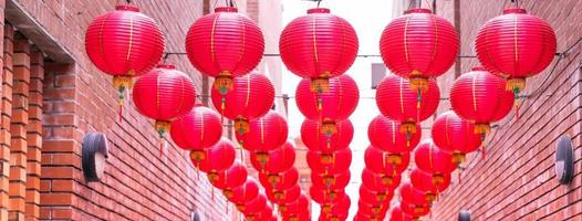 mooie ronde rode lantaarn die op oude traditionele straat hangt, concept van Chinees maannieuwjaarsfestival, close-up. het onderliggende woord betekent zegen. foto