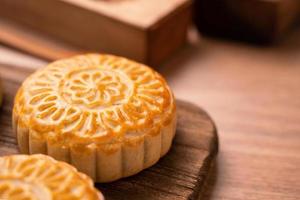 ronde vormige vers gebakken maan cake gebak - chinese moonckae voor mid-herfst maan festival op houten achtergrond en dienblad, close-up, kopieer ruimte foto