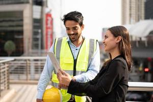 zakenvrouw en werknemer bespreken met ingenieur op bouwplaats. foto
