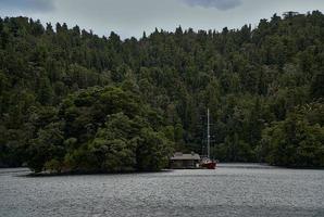 drijvend huis in het midden van het meer omgeven door bomen foto