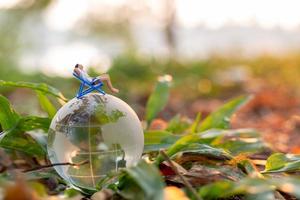 miniatuur mensen zonnebaden op kristallen bol in het park foto