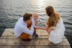 vader en moeder nemen hun eenjarige zoon bij de hand. foto