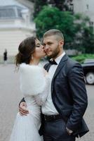 de bruidegom in een grijs pak en de bruid in een grijze jurk kijken elkaar aan, close-up portret foto