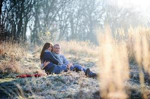 jonge mooie mode sensuele paar verliefd zittend in de winter koude veld foto