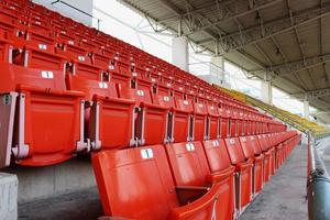 rode stoelen op de tribune in het stadion foto