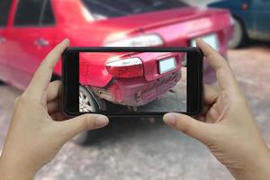 hand met smartphone maak een foto op de plaats van een auto-ongeluk, auto-ongeluk voor verzekering