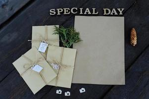 bruine kraft enveloppen gebonden met een oude tourniquet op oude houten ondergrond met kopieerruimte. handgemaakte cadeauverpakking. foto