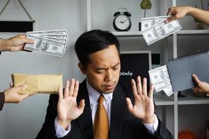 corruptie en omkoping, zakenmanmanager die weigert geld dollarbiljetten te ontvangen om een contract af te handelen foto