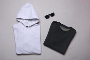 gevouwen sweatshirt en hoodie mockup op grijze achtergrond. platliggend sjabloon voor herenuitlopers foto