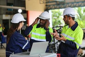 industrieel ingenieur of werknemer die een helm draagt terwijl hij in een zware industriële fabriek staat. het onderhoud van het werken aan industriële machines en het controleren van de installatie van het beveiligingssysteem in de fabriek. foto