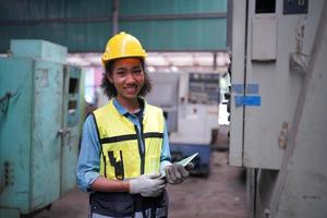 vrouwelijke onderhoudsingenieurs werken voor de geautomatiseerde reparatie van cnc-machines aan een onderhoudschecklist aan de productielijn. foto