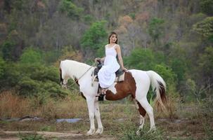 jonge vrouw met haar paard in avondzonsonderganglicht. buitenfotografie met fotomodel meisje. levensstijl stemming foto