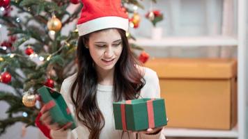 vrouw s handen inwikkeling kerst geschenkdozen, close-up. bijgesneden vrouw zit en bereidt natuurlijke eco-cadeaus voor op de bank met decorelementen en items. vrolijk kerstfeest of nieuwjaar diy verpakkingsconcept. foto