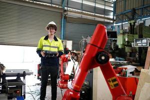 professionele industriële fabrieksmedewerker die met machineonderdelen werkt, industriële apparatuur en robotarmen controleert en test in een grote fabriek voor elektrische elektronica, draad- en kabelfabriek foto