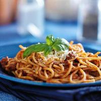 spaghetti in bolognese saus op blauw bord