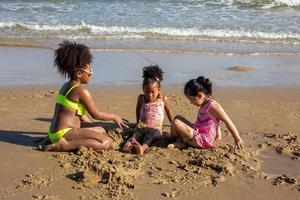 kinderen spelen rennend op zand op het strand foto