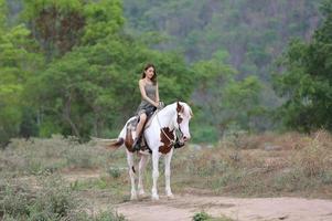 jonge vrouw met haar paard in avondzonsonderganglicht. buitenfotografie met fotomodel meisje. levensstijl stemming foto