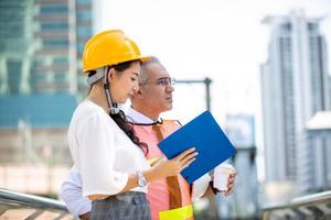 de ingenieur en zakenmensen geven high five tegen bouwen. het concept van engineering, constructie, stadsleven en toekomst. foto