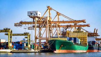 container laden in een vrachtschip met industriële kraan. containerschip in logistiek bedrijf voor import en export. industrie en transport concept. foto