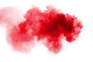 rode poederexplosie op witte achtergrond. bevriezen beweging van rode stofdeeltjes spatten. foto