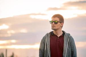 portret van een jonge man met een bril op straat foto