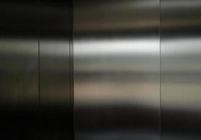 roestvrijstalen grote plaat met licht dat het oppervlak raakt voor achtergrond, in passagierslift, reflectie van licht op een glanzende metalen textuur, roestvrijstalen achtergrond. foto
