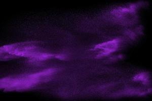 paarse deeltjes stof splash op zwarte achtergrond. paars poeder explodeert. foto