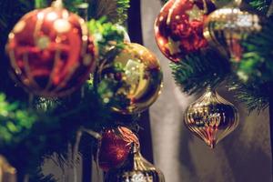 kerstbal die aan een versierde kerstboom hangt. vervaging en retro filtereffect. foto