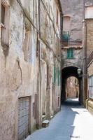 verticaal schot van de smalle straat met oude stenen gebouwen. Italië. foto