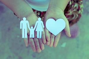 kinderen handen met klein model van hart en familie, concept familie foto