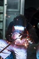 arbeiders in het masker lassen staal in werkplaats foto