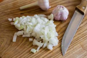 koken van sperziebonen en knoflook, verse groenten op houten tafel foto