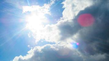 zon op de achtergrond van een blauwe lucht met witte wolken foto