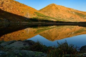 weerspiegeling van de berg turku in het stuwmeer van het meer nesamovyto, het meer nesamovyte en de berg turkul, herfstlandschappen van de karpaten. foto