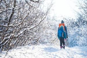 vrouw met een kind op een winterwandeling in de bergen. foto